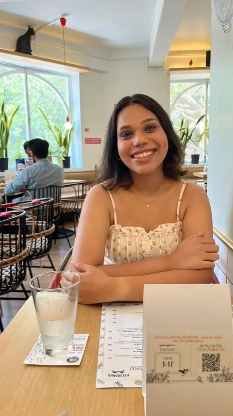 Ruth Koli, a Uhtend Pass subscriber, smiling at a café table