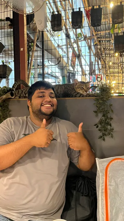 Travis Almedia, a Uhtend Pass subscriber, giving two thumbs up at a cat café